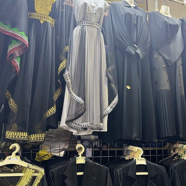 Black abayas hanging in a row