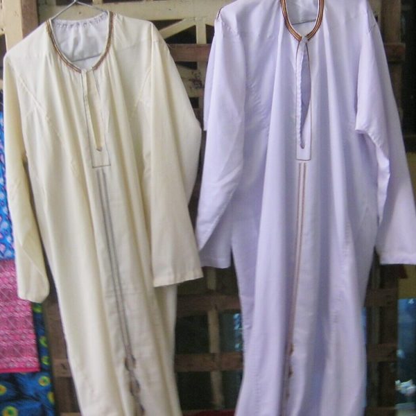 Two white dishdashas on hangers