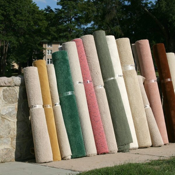 Rolled rugs leaning against a stone wall