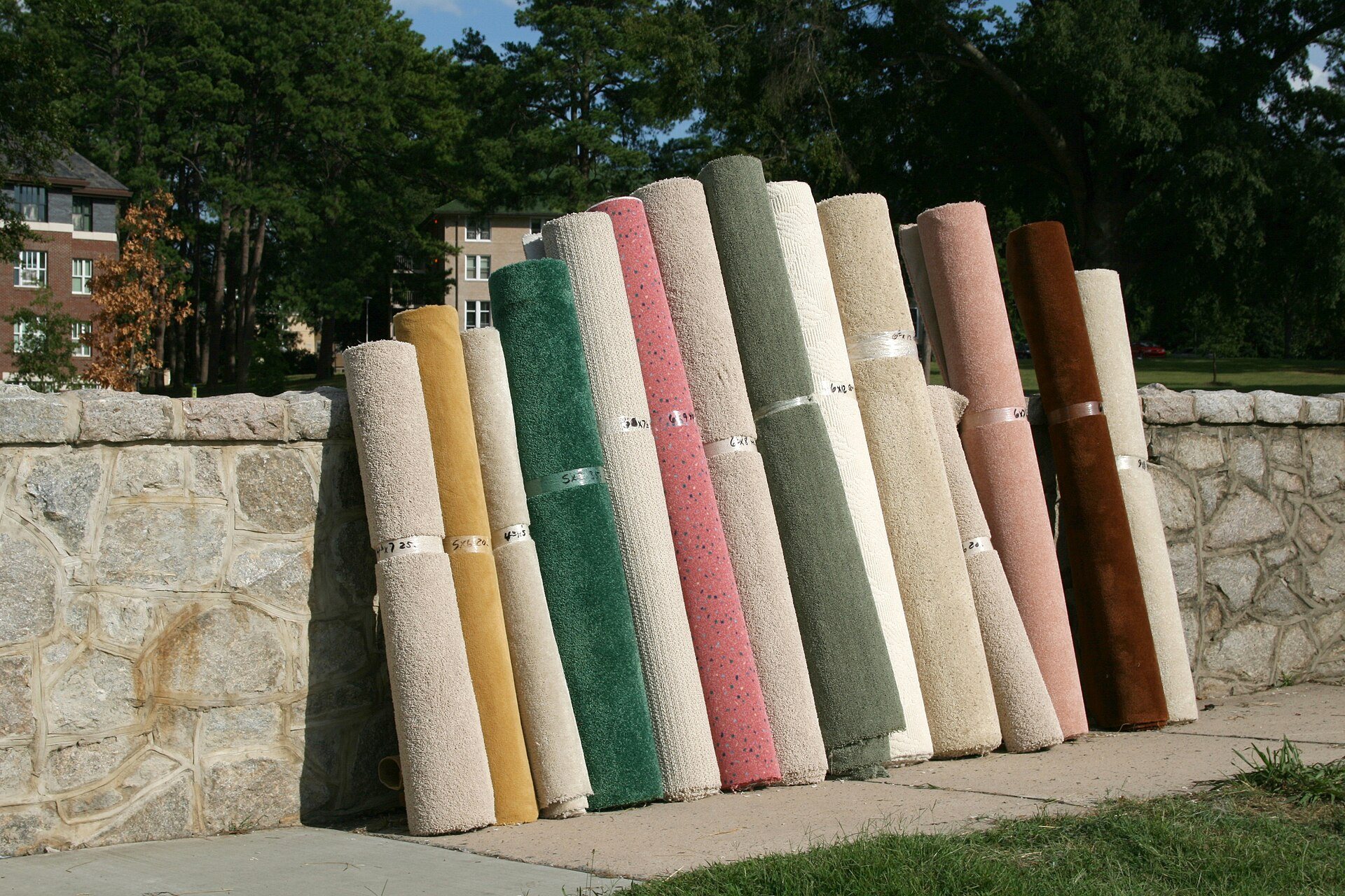 Rolled rugs leaning against a stone wall